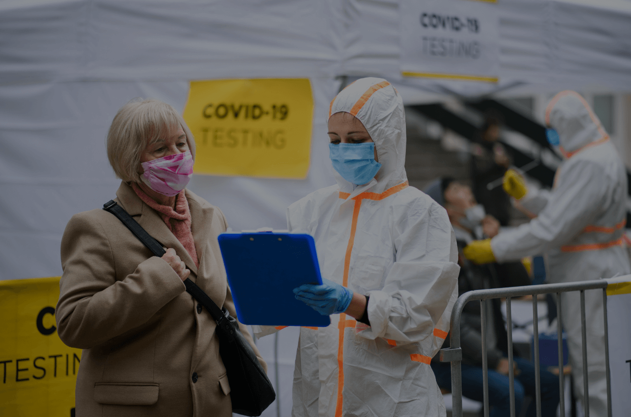 COVID-19 testing centre and healthcare worker assisting a patient.
