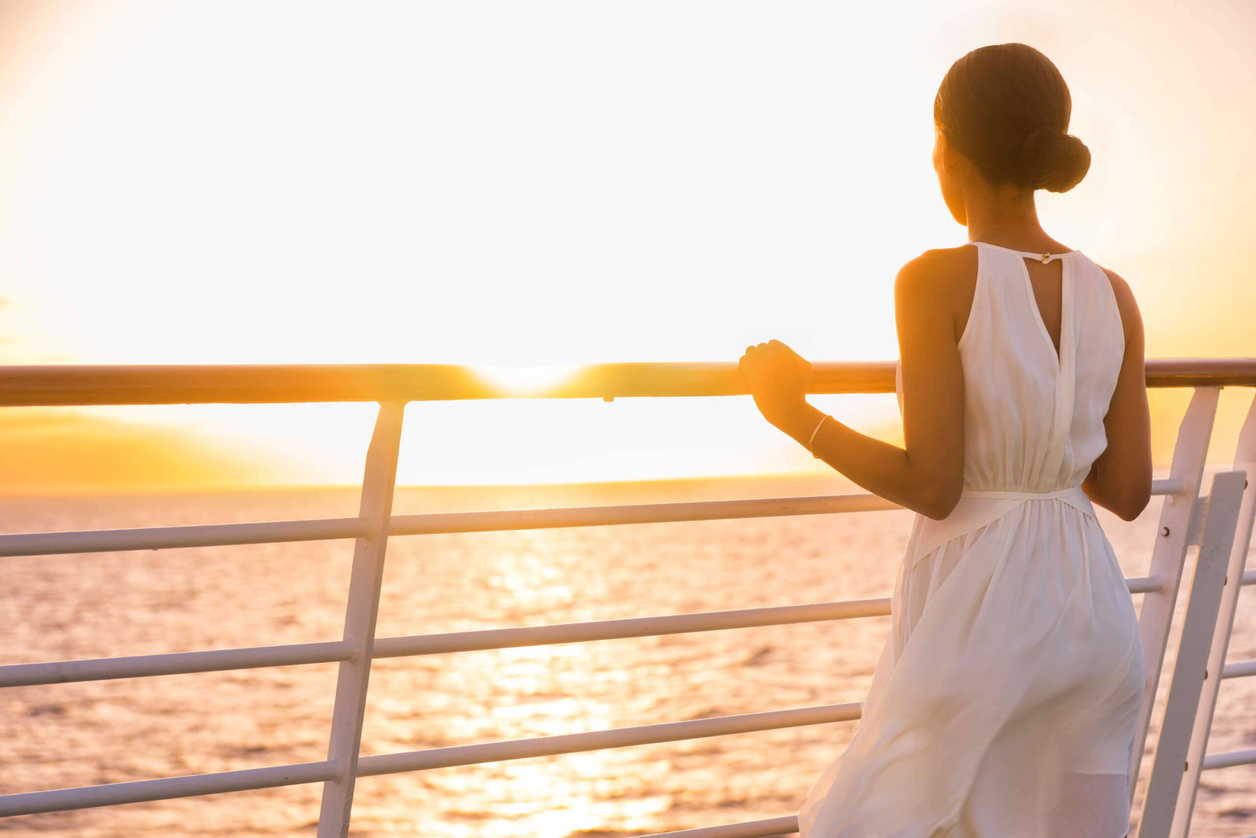 Woman on cruise ship deck enjoying a luxurious UK sailing experience.