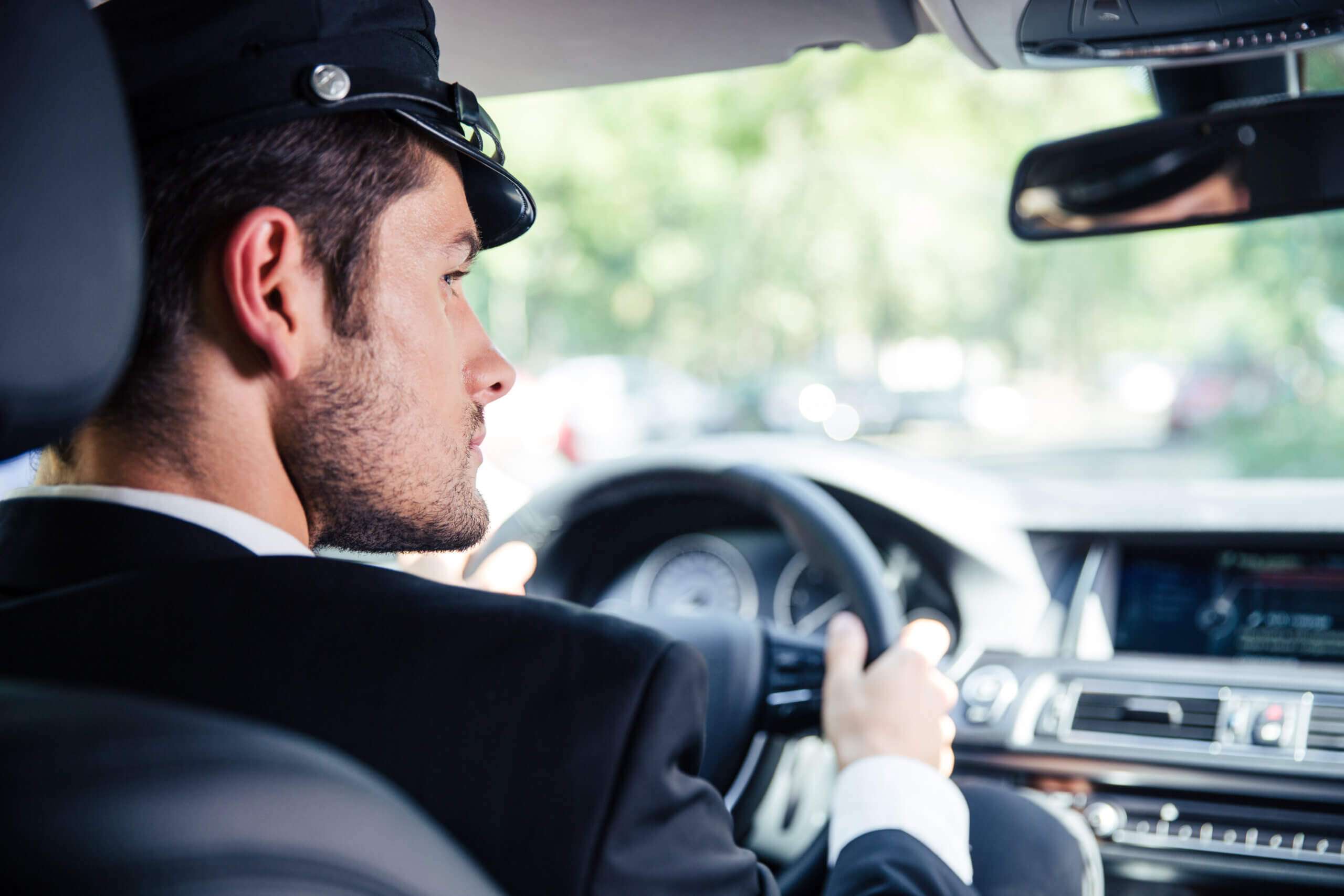 Chauffeur in executive car driving, luxury chauffeur service for business meetings.