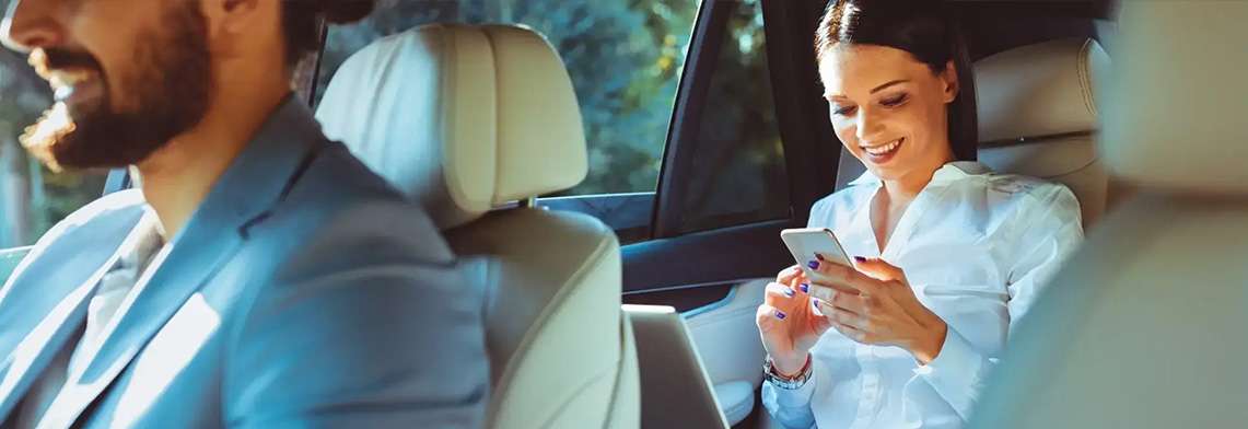Luxury airport transfer in London, passenger using phone in vehicle