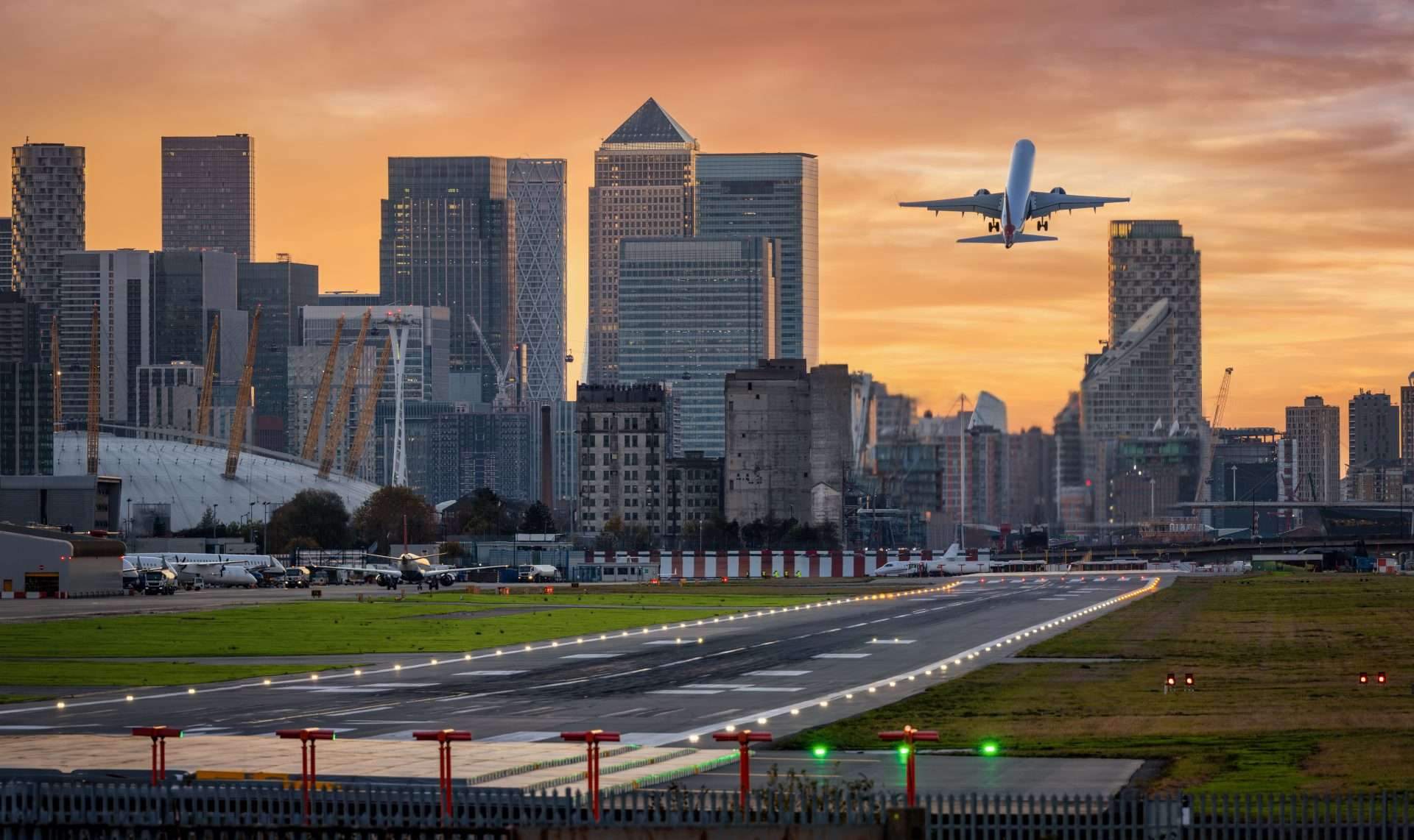London skyline and airplane landing illustrating airport transfer services.